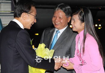 베트남에서 열리는 ‘아세안+3’ 정상회의에 참석하기 위해 28일 저녁 베트남 하노이 노이바이공항에 도착한 이명박 대통령이 베트남 하훙끄엉 법무장관(가운데)의 영접을 받고 있다. 하노이=김동주 기자 zoo@donga.com