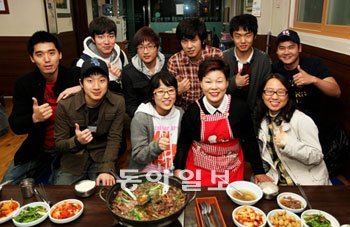 최필금 씨(앞줄 오른쪽에서 두 번째)와 하숙생들이 서울 성북구 종암동 최 씨 하숙집 식당에 모여 환하게 웃고 있다. 25년 동안 고려대 앞에서 하숙집을 운영한 최 씨는 3일 고려대에 1억 원의 발전기금을 기부했다. 사진 제공 고려대