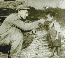 A foreign soldier gives food to a starving child during the Korean War in the early 1950s. Photo: Dong-a Daily DB