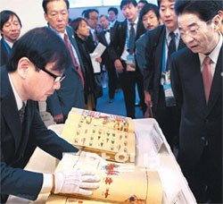 한국으로 돌아올 도서들 김성환 외교통상부 장관과 마에하라 세이지 일본 외상이 14일 일본 요코하마 인터콘티넨털 호텔에서 ‘대례의궤’ 등 문화재급 도서 1205권을 반환하는 협정서에 서명했다. 서명식이 끝난 뒤 일본 정부 관계자들이 일본이 약탈해간 대례의궤가 어떤 책인지 호기심 어린 표정으로 살펴보고 있다. 대례의궤는 고종이 대한제국 초대 황제가 된 즉위식을 기록한 것으로 1884년에 만들어졌다. 요코하마=김동주 기자 zoo@donga.com