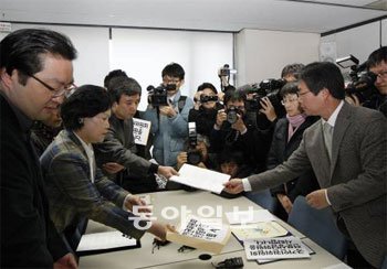 현병철 국가인권위원장의 사퇴를 요구하고 있는 인권위 전문, 자문, 상담위원들이 15일 서울 중구 무교동길 인권위 사무실에서 사퇴서와 위촉장을 손심길 사무총장(오른쪽)에게 제출하고 있다. 이날 집단 사퇴한 위원들은 전체 위원의 4분의 1 정도인 61명이다. 김재명 기자 base@donga.com