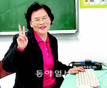 18일 2011학년도 대학수학능력시험을 치르는 박봉월 씨가 서울 마포구 염리동 일성여고 교실에서 손으로 승리의 ‘V’자를 그리며 환하게 웃고 있다. 사진 제공 일성여고