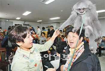 서울 노원구 중계본동 중증장애인 복지시설 ‘늘 편한 집’에서 생활하는 한 장애인이 9일 어린이대공원 동물원이 연 ‘이동 동물원’ 행사에서 머리 위에 원숭이가 올라가자 즐거워하고 있다. 원대연 기자 yeon72@donga.com