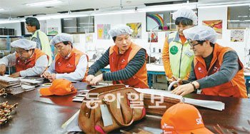 SK가 설립 자금을 보탠 핸드백 부품 제조 사회적 기업 ‘고마운 손’에 지난해 최태원 회장(오른쪽에서 세번째)이 방문해 자원봉사를 하고 있다. 사진 제공 SK그룹