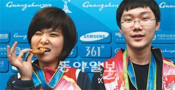 광저우 아시아경기에서 처음 정식 종목으로 채택된 바둑에서 한국에 첫 금메달을 안긴 이슬아(왼쪽)와 박정환. ‘바둑 얼짱’이라는 
별명을 얻은 이슬아가 혼성복식에서 딴 금메달을 깨물어 보고 있다. 광저우=변영욱 기자 cut@donga.com