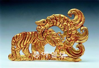 중국 신장문물고고연 구소가 소장한 ‘괴수가 호랑이를 물고 있는 금장식’. 기원전 2세기∼기원전 1세기에 제작한 허리띠 장식물로 추정된다. 사진 제공 국립중앙박물관