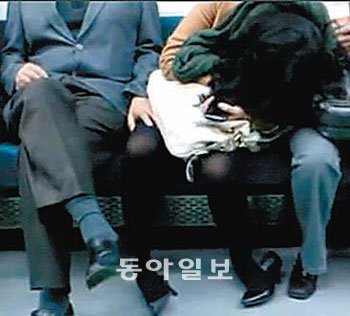 한 승객의 휴대전화에 찍힌 지하철 내 성추행 장면. 왼쪽에 앉아있는 남성이 술에 취해 잠든 여성의 허벅지를 더듬고 있다. 유튜브 동영상 캡처