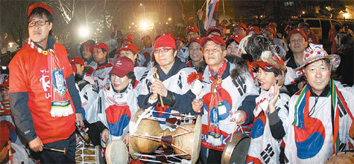 간절히 기도했는데…태극기를 몸에 두르고 장구와 꽹과리 등 을 든 축구팬들이 3일 새벽 경기 과천의 한 음식점에 모여 2022년 월드컵의 한국 개최를 기원했다. 하지만 2022년 대회 개최지가 카타르로 확정되자 허탈한 표정을 감추지 못하고 있다. 과천=연합뉴스