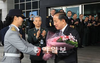 김태영 전 국방부 장관(오른쪽)이 4일 이임식을 마친 뒤 한민구 합참의장(가운데) 등의 환송 속에 한 여군에게서 꽃다발을 받고 있다. 이훈구 기자 ufo@donga.com