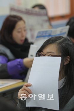 “내 점수로 어느 대학?” 수험생들에게 대학수학능력시험 성적표가 배부된 8일 서울 종로구 배화여고 고3 학생이 자신의 점수를 확인한 뒤 성적표로 얼굴을 가리고 있다. 박영대 기자sannae@donga.com