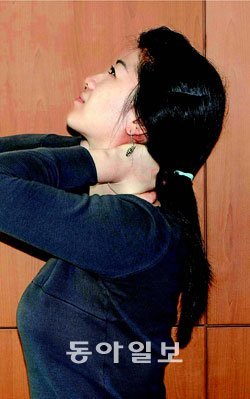 목 건강을 위해서는 한 자세로 가끔씩 손으로 목을 잡고 뒤로 젖히는 스트레칭을 해주는 것이 좋다. 동아일보 자료 사진