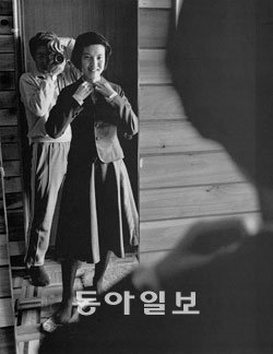 큰딸이 태어나 결혼할 때까지 성장 과정을 오롯이 담은 사진집 ‘윤미네 집’에 실린 사진들을 선보인 ‘전몽각 그리고 윤미네 집’전이 서울 한미사진미술관에서 열리고 있다. 사진 속에서 단정하게 교복을 입은 딸의 모습을 촬영 중인 아버지의 모습이 보인다. 사진 제공 한미사진미술관 ⓒ전몽각