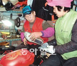 “가난한 집 아이들 돕고 싶어요” 광주 서구 양동시장 주차장 귀퉁이의 신세계구둣방에서 김주술 씨 부부가 구두를 손질하고 있다. 김 씨 부부 앞에는 결식아동들을 위한 돼지저금통이 놓여 있다. 이형주 기자 peneye09@donga.com