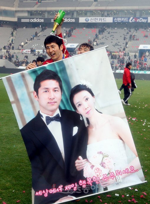 FC서울 골키퍼 김용대가 12월 5일 팀의 리그 우승이 확정된 뒤 아내 염세희 씨와 함께 찍은 웨딩사진을 들며 기뻐하고 있다. 김용대는 12월 12일 결혼식을 올렸다. 스포츠동아DB.