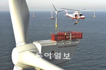 헬리콥터가 지난해 가동을 시작한 독일 해상풍력단지 ‘알파벤투스’의 해상풍력발전기에 접근해 기술자를 내려주고 있다. 이 풍력발전기는 1기당 5MW의 전력을 생산한다. 일부 풍력발전기에는 헬리콥터가 이착륙할 수 있는 헬리패드도 설치돼 있다. 사진 제공 아레바