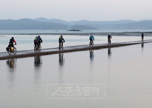 썰물때마다 드러나는 웅도와 육지를 연결하는 길을 건너고 있는 자전거식객들. 이 길은 하루 두차례 간조시에만 열린다.