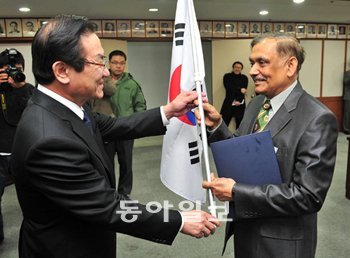 24일 정부과천청사 법무부 회의실에서 열린 귀화자 국적증서 수여식에서 이귀남 법무
부 장관(왼쪽)이 10만 번째 귀화 허가자인 인도 출신 로이 알록 꾸마르 부산외국어대
교수에게 태극기와 국적증서를 전달하고 있다. 과천=박영대 기자 sannae@donga.com