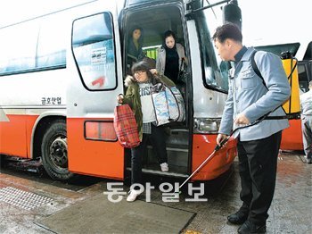 버스터미널에 발판소독기 구제역이 경남지역까지 번지면서 24일 전국 각지의 사람들이 모이는 광주 고속버스터미널 주차장에 구제역 예방을 위한 발판소독기가 설치됐다. 터미널 직원들이 발판에 소독약재를 뿌리고 있다. 광주=박영철 기자 skyblue@donga.com