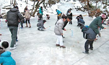 휴일인 23일 경북 청도의 운문산자연휴양림을 찾은 이용객들이 ‘얼음 팽이치기’ 체험을 하고 있다. 사진 제공 운문산자연휴양