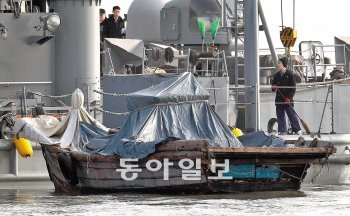 8일 연평도 해군해상전진기지에 예인된 북한어선. 5일 월남한 31명의 북한 주민들은 이 배를 타고 서해 북방한계선(NLL)을 넘어왔다. 나무로 만든 5t 규모의 동력선으로 통상 10여 명이 타고 조개잡이 조업을 하며 속도는 10노트를 넘지 않는 것으로 알려졌다. 탈북자들에 따르면 북한에서는 주민들의 탈북을 막기 위해 속력이 빠른 배를 금지하고 있으며 철로 만든 배는 부식 때문에 관리가 어렵고 가격이 비싸 주민들은 나무로 만든 배를 선호한다고 한다. 연평도=박영대 기자 sannae@donga.com