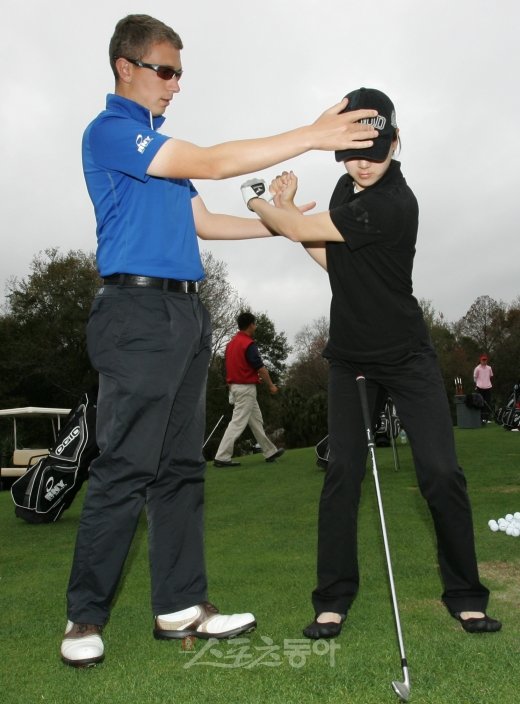 KLPGA 투어에서 활약 중인 이정민(오른쪽)이 RNY 골프 인스티튜트에서의 전지훈련 도중 로빈 사임스 코치로부터 자세교정을 받고 있다.