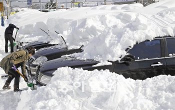 11, 12일 강원 동해안에 100㎝가 넘는 폭설이 내려 대중교통 운행이 중단되는 등 도심 기능이 사실상 마비됐다. 12일 동해시에서 주민들이 승용차 높이만큼 덮인 눈을 삽으로 퍼내고 있다. 동해=홍진환 기자 jean@donga.com