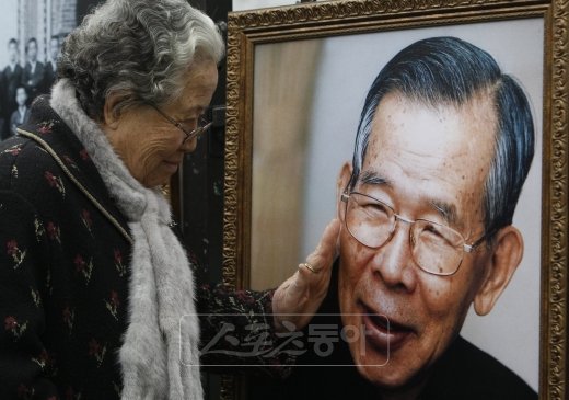 “당신을 사랑합니다”  한 추모객이 고 김수환 추기경의 사진 속 얼굴을 어루만지고 있다. 스포츠동아DB