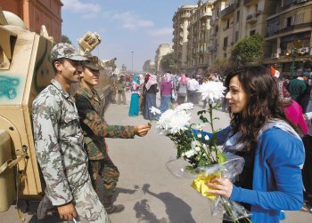 “軍 중립에 감사” 꽃다발 12일 이집트 여성이 수도 카이로 타흐리르 광장을 지켜 온 군인들에게 감사의 뜻으로 큼직한 흰 꽃을 선물하고 있다. 이집트군은 18일간의 반정부 시위 기간에 중립을 지켰으며, 호스니 무바라크 대통령에게 결정적인 하야 압력을 넣었다. 카이로=AP 연합뉴스