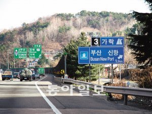 경남 김해시에서 부산방면 남해고속도로 지선에 설치된 ‘부산신항’ 표지판. ‘부산항 신항’에서 가운데 글자를 덮어버렸다.
