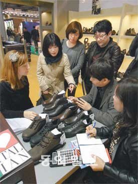 7일 이탈리아 밀라노에서 열린 ‘2011 밀라노 국제구두박람회(MICAM)’에서 신세계 이마트 신발 구매 담당자들이 올해 가을·겨울용 구두 신상품을 주문하기 위해 이탈리아 신발업체의 전시관에서 상담을 벌이고 있다. 신세계 이마트 제공