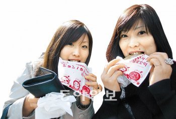 신오쿠보에서 인기인 ‘종로호떡’을 맛보고 있는 일본인 모녀.