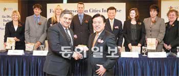 21일 오전 서울 롯데호텔에서 로히트 탈워 FCCI 사무국장(앞줄 왼쪽)과 정경원 서울시 문화관광디자인본부장이 FCCI 창립 협약서에 서명한 뒤 악수하고 있다. 뒷줄에는 FCCI에 참가한 7개 도시 대표들. 김미옥 기자 salt@donga.com