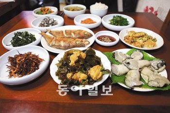 매물도에서 맛볼 수 있는 어부밥상의 한상차림. 앞줄 가운데부터 시계방향으로 성게알 미역쌈, 가시리, 몰, 볼락 열기구이, 부침, 벚굴.