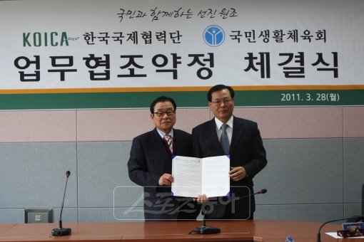 국민생활체육회 이강두 회장(왼쪽)과 한국국제협력단 박대원 이사장이 양해각서 체결 후 각서를 들고 포즈를 취하고 있다.