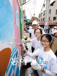 하영구 한국씨티은행장(맨 뒤쪽)이 지난해 가을 서울 성동고등학교에서 열린 ‘글로벌 지역사회 공헌의 날’ 행사에 참석해 직원 가족들과 담장에 벽화를 그리고 있다. 한국씨티은행 제공