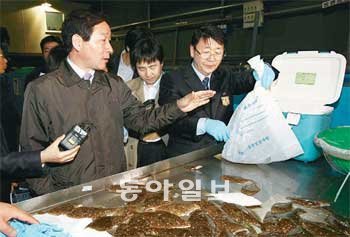 7일 인천항 앞 보세창고에서 유정복 농림수산식품부 장관(왼쪽)이 수입 수산물의 방사
능 검사 시료 채취 과정을 지켜보고 있다. 농림수산식품부 제공