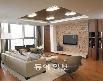 동부건설의 ‘센트레빌 아스테리움 서울’ 208㎡ 거실. 천장과 바닥, 문 등에 짙은 색 원목을 사용해 고급 승용차의 실내처럼 중후한 분위기가 풍긴다. 동부건설 제공