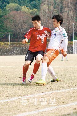 잉글랜드 프로축구 프리미어리거 출신인 경찰청 김두현(왼쪽)이 14일 용인 경찰대 운동장에서 열린 R리그(프로 2군) 강원 FC와의 경기에서 상대 선수와 몸싸움을 벌이고 있다. 경찰청 제공