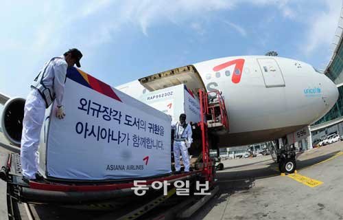 “조심 또 조심” 외규장각 도서 든 컨테이너 하역 인천공항 직원들이 14일 오후 일반 여객기 화물칸에서 외규장각 도서 75권이 든 컨테이너를 내리고 있다. 항온·항습 기능이 있는 특수컨테이너로, 프랑스 측이 도서가 든 나무상자를 포개 담지 말라고 요청해 두 개의 컨테이너에 나눠 담았다. 인천=김재명 기자 base@donga.com