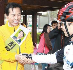 자전거 애호가 손잡고 최문순 민주당 강원도지사 후보(왼쪽)가 24일 춘천시 온의동 공지천 공원에서 운동을 나온 한 시민의 손을 잡으며 지지를 호소하고 있다. 춘천=전영한 기자 scoopjyh@donga.com