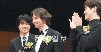 24일 서울 서초구 예술의전당 콘서트홀에서 폐막한 ‘LG와 함께하는 제7회 서울국제음악콩쿠르’에서 1위를 차지한 게오르기 그로모프 씨(가운데)가 수상 소감을 밝히기 위해 앞쪽으로 걸어가자 공동 2위를 수상한 미국의 숀 천 씨(왼쪽), 한국의 정한빈 씨가 박수를 보내고 있다. 양회성 기자 yohan@donga.com