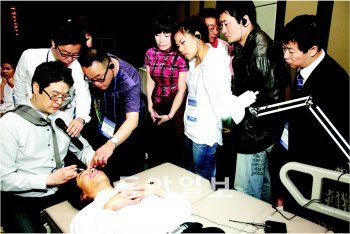 태국 방콕에서 열린 1회 국제최소침습심포지엄에 참석한 고익수 국제침습성형학회 회장이 현장에서 환자에게 프티성형의 원조격인 보톡스 치료를 하고 있다.