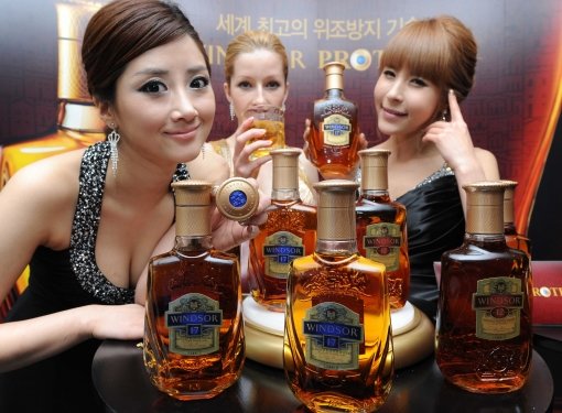 모델들이 새로운 위조 방지 장치 ‘윈저 프로텍트’를 적용한 위스키 ‘윈저’를 선보이고 있다.