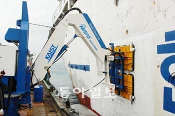 26일 부산 한국해양대 앞바다에서 KAIST가 개발한 모바일하버 자동도킹장치의 로봇 팔이 배를 끌어당기고 있다. 로봇 팔 끝에는 진공 흡착 패드가 있어 배에 손상을 주지 않고 당길 수 있다. KAIST 제공