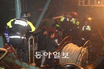 해무가 짙게 낀 7일 오후 우리 해역에서 불법조업을 하던 중국 선원들이 인천해경 단속대원들에게 제압당해 갑판에 서 있다. 중국 어선 뒤로 우리 측 단속대원들이 타고 온 고속단정이 보인다. 대청도 3005함=변영욱 기자 cut@donga.com