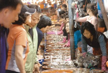 소래포구 꽃게 흥정 26일 인천 남동구 논현동 소래포구어시장을 찾은 시민들이 꽃게를 고르고 있다. 요즘 잡히는 암꽃게는 등딱지에 알이 꽉 차 있어 찜이나 탕으로 요리하거나 게장을 담가 먹어도 좋다. 김영국 동아닷컴 객원기자 press82@donga.com