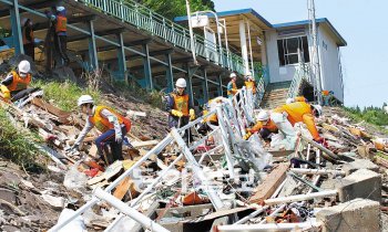 동일본 대지진 피해지역인 미야기 현 미나미산리쿠 마을에서 24일 한일사회문화포럼 자원봉사자들이 건물 잔해를 치우고 있다. 한일사회문화포럼 제공