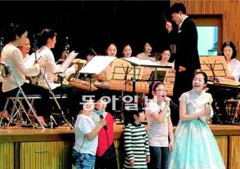 구로초등학교 어린이들과 이유림 씨가 20일 청년예술단의 반주에 맞춰 국악동요를 부르고 있다. 서영수 기자 kuki@donga.com