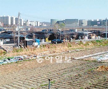 서울 송파구 문정지구가 2012년까지 완공을 목표로 공사를 시작했지만 일부 주민의 추가 보상금 지급 문제 등으로 표류하고 있다. 이들은 주거용 비닐하우스(가운데 검은색 건물)를 짓고 농성을 벌이고 있다. 오른쪽 뒤편으로 쇼핑몰 가든파이브가 보인다. SH공사 제공