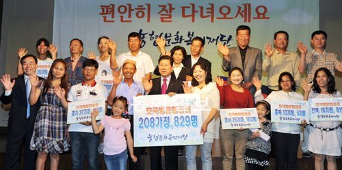 14일 서울 영등포구 여의도동 63컨벤션센터에서 열린 ‘농촌 다문화가정 모국방문 항공권 전달식’에서 다문화가정 가족들이 최원병 농협중앙회 회장(앞줄 가운데)으로부터 항공권과 체재비를 전달받고 기뻐하고 있다. 농협 제공